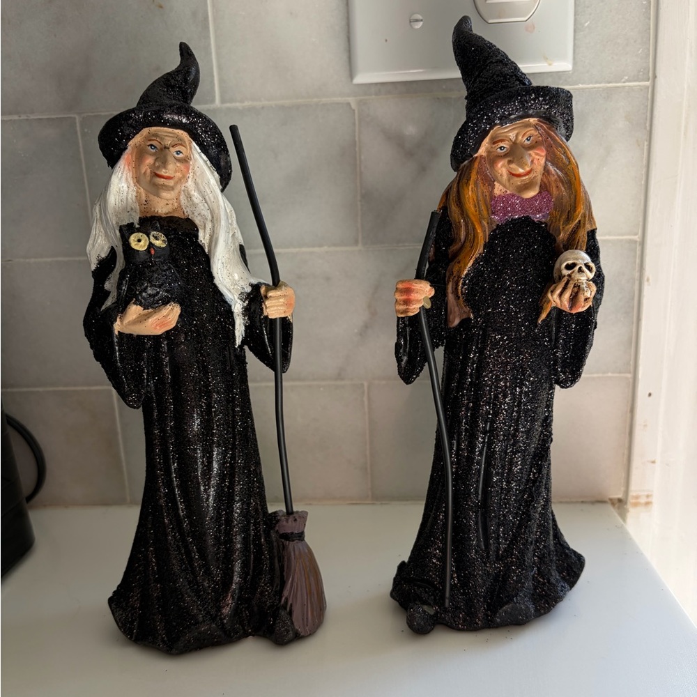 Witch set of figurines are resin statues featuring glittery black gowns